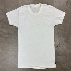 May include: A white, short-sleeved t-shirt with a crew neck. The shirt is made of a soft, textured fabric and has a tag at the neckline. The shirt is laid flat on a gray surface.