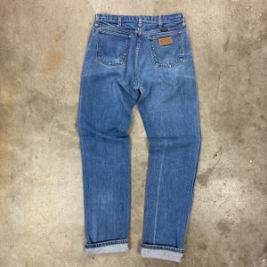 K&ouml;nnte beinhalten: Hellblaue Jeans mit klassischem F&uuml;nf-Taschen-Design. Die Jeans haben einen braunen Lederaufn&auml;her auf der Ges&auml;&szlig;tasche und sind an den Kn&ouml;cheln umgeschlagen. Die Jeans bestehen aus strapazierf&auml;higem Denim-Material.