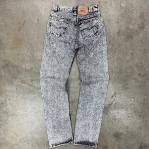 Può includere: Jeans in denim lavato con acido, a vita alta e design classico a cinque tasche. I jeans presentano un motivo nero e grigio sbiadito, una toppa in pelle e il logo del marchio Levi's.