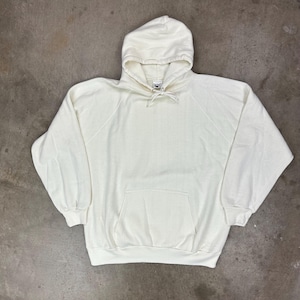 Könnte beinhalten: Eine weiße Keramik-Tasse mit schwarzem Henkel und dem Text "But First, Coffee" in schwarzer, fetter Schrift. Die Tasse steht auf einer weißen Oberfläche.