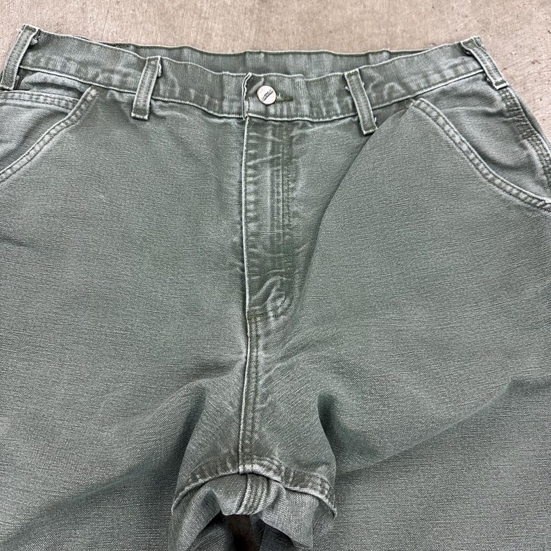 May include: A white ceramic mug with a black handle and the text "But First, Coffee" in a handwritten style. The mug is on a white surface. The mug is approximately 4 inches tall.