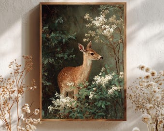 May include: A rectangular wall art print in a wooden frame featuring a painting of a spotted fawn standing amidst dark green foliage and clusters of small white flowers. The fawn is positioned in the centre, facing right, surrounded by dense forest greenery.