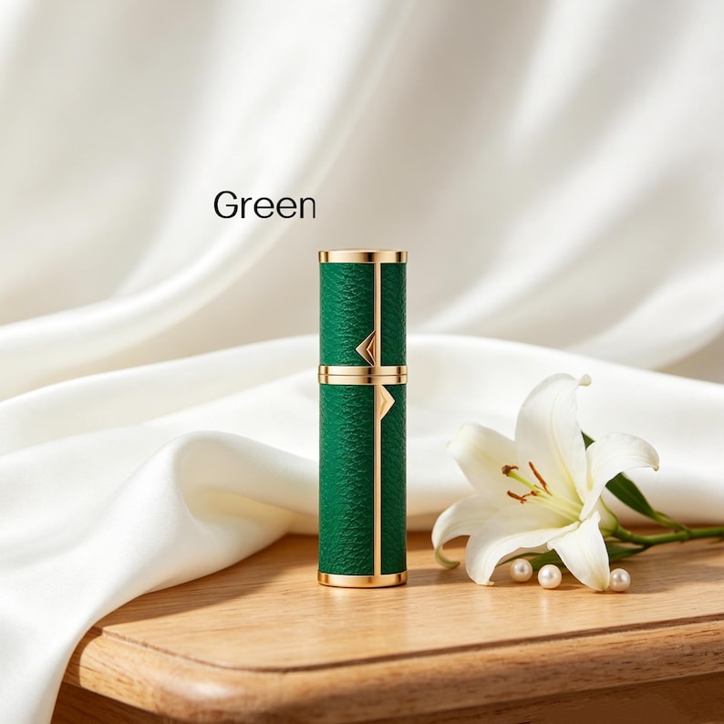 K&ouml;nnte beinhalten: Ein gr&uuml;ner Parf&uuml;mzerst&auml;uber mit goldenen Akzenten. Die zylindrische Flasche hat eine strukturierte Oberfl&auml;che und ist mit "Green" beschriftet. Eine wei&szlig;e Lilie und Perlen liegen neben der Flasche auf einer Holzoberfl&auml;che.