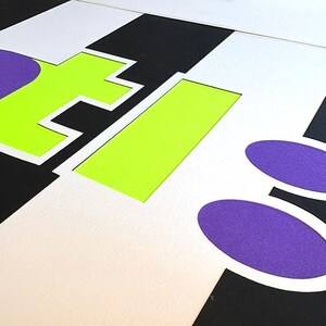 May include: Abstract graphic design with the letters "NTI" in purple and neon green, set against a black and white striped background. Two purple ovals are in the lower right corner. The design has a modern, geometric aesthetic.