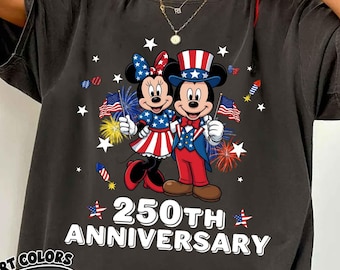 May include: Dark grey t-shirt featuring Mickey and Minnie Mouse in patriotic outfits, holding flags and surrounded by fireworks and stars. The text "250th Anniversary" is displayed below the characters. The shirt has the Comfort Colors Pepper logo.