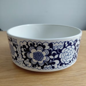 Puede incluir: Cuenco de cerámica blanco con un patrón floral azul en el exterior. Las flores están estilizadas con un diseño simétrico y detallado. El cuenco tiene una forma simple y redondeada y un acabado liso y brillante. Ideal para la cocina.