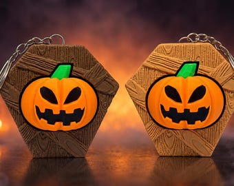 May include: Two hexagonal keychains featuring a raised orange jack-o'-lantern with a green stem and black carved facial features. The background of each keychain has a textured wood grain pattern in brown and tan, attached to a silver metal ring.