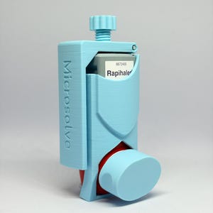 May include: A light blue 3D-printed holder for a Rapihaler inhaler canister. The holder features a vertical adjustment knob at the top and the word Microsolve embossed vertically on the side. The inhaler canister is partially visible inside the frame.