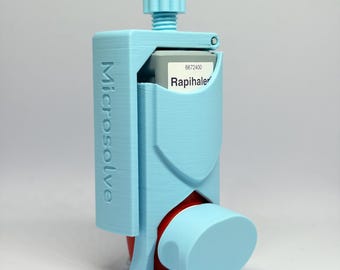 May include: A light blue 3D-printed holder for a Rapihaler inhaler canister. The holder features a vertical adjustment knob at the top and the word Microsolve embossed vertically on the side. The inhaler canister is partially visible inside the frame.