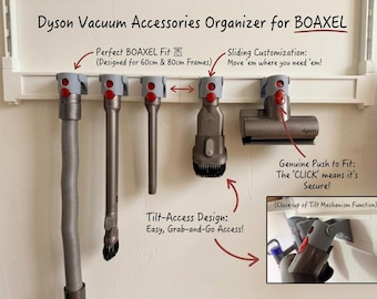 May include: A gray plastic vacuum accessory organizer mounted on a white wall rail, designed for 60cm and 80cm frames. It features five sliding mounts with red release buttons to hold various Dyson vacuum attachments securely in place.