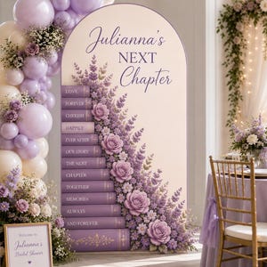 May include: An arched event backdrop featuring a stack of purple books with the text Julianna's NEXT Chapter, decorated with lavender and white balloons and purple floral arrangements. A small sign reads Welcome to Julianna's Bridal Shower.