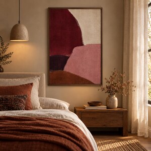 May include: A framed rectangular wall art piece featuring abstract color blocks in deep burgundy, soft pink, dark purple, and earthy brown tones. The artwork has a textured appearance and is displayed on a wall above a wooden bedside table.