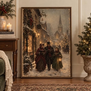 May include: A framed rectangular wall art print depicting a snowy Victorian street scene at night. Three figures in period clothing stand in the foreground holding books and a lantern, with a church steeple and lit buildings in the background.