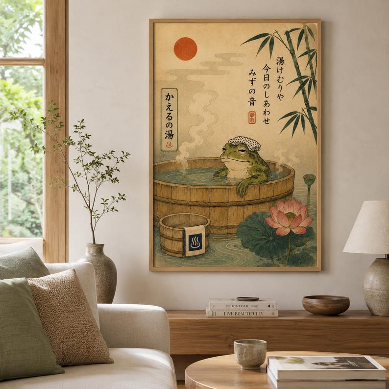 K&ouml;nnte beinhalten: Ein vertikaler Wandkunstdruck, der einen gr&uuml;nen Frosch mit einem wei&szlig;en Handtuch auf dem Kopf zeigt, der in einem Holzzuber badet. Die Illustration enth&auml;lt eine rote Sonne, Bambusstangen, eine rosa Lotusbl&uuml;te und japanische Schriftzeichen.
