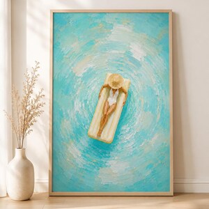 May include: A framed wall art print featuring an oil painting of a figure in a white swimsuit and straw hat resting on a yellow pool float. The background depicts textured, swirling turquoise and white water ripples in a circular pattern.