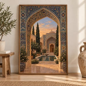 May include: A rectangular framed wall art print depicting an architectural view through an ornate archway with blue and gold tile patterns. The scene shows a courtyard with a central fountain, stone buildings, tall cypress trees, and a sunset sky.