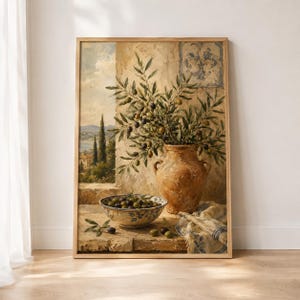 May include: A framed wall art print depicting a Mediterranean scene with a large terracotta vase filled with olive branches, a bowl of olives, and a patterned cloth on a stone ledge, set against a landscape with cypress trees and a cloudy sky.