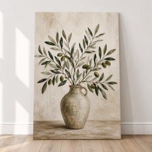 Può includere: Un quadro rettangolare su tela raffigurante un dipinto di un arrangiamento di rami d'ulivo in un vaso di ceramica arrotondato di colore chiaro. L'opera presenta toni beige e crema con foglie d'ulivo verdi e piccole olive scure.