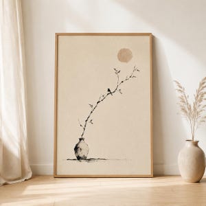 May include: A framed wall art print featuring a black ink illustration of a small bird perched on a thin, leafless branch extending from a textured vase. A soft, beige circular shape sits in the upper portion against a light cream background.