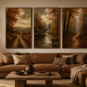 May include: A triptych of three vertical wall art prints featuring autumn forest landscapes. The left panel shows a dirt path through hills, the centre panel depicts a flowing stream in a wooded area, and the right panel displays a forest trail.