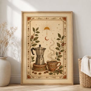 May include: A framed wall art print featuring a silver moka pot on a pedestal and a steaming patterned mug, surrounded by coffee plant branches with red berries. The design includes a sun and crescent moon motif within a decorative border.