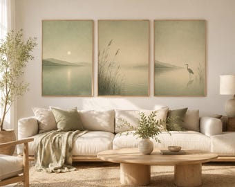 Könnte beinhalten: Ein Set aus drei vertikalen Wandbildern in hellen Holzrahmen, die eine ruhige Landschaft mit einem stillen See, fernen Bergen, hohem Schilf und einem einsamen Reiher in sanften, gedämpften Grün- und Beigetönen darstellen.