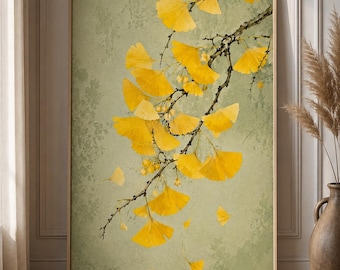May include: A framed vertical wall art print featuring a detailed illustration of a ginkgo branch with vibrant yellow fan-shaped leaves against a textured, muted sage green background. The artwork depicts several leaves falling from the branch.
