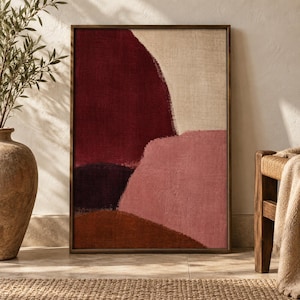 May include: A rectangular framed wall art piece featuring an abstract composition of layered organic shapes in deep burgundy, muted pink, dark brown, and beige tones, all set against a textured canvas background with a visible woven fabric grain.