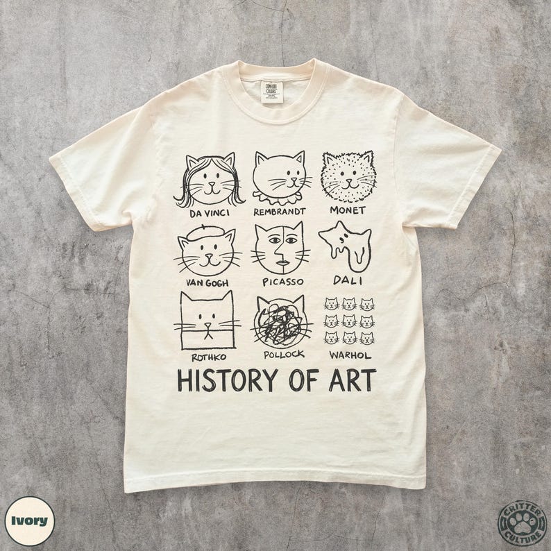 以下が含まれることがあります： アイボリー色のTシャツ。ダ・ヴィンチやウォーホルなど、有名なアーティストにインスパイアされた猫のポートレートの白黒イラストが描かれています。「HISTORY OF ART」の文字が猫のポートレートの下にプリントされています。