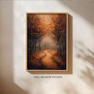 May include: A framed art print depicts a winding path through a forest. The artwork features trees with orange and brown foliage, a pathway, and a soft, warm color palette. The text "STILL MEADOW STUDIOS" is printed at the bottom.