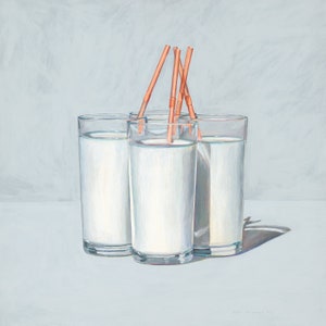 May include: Four clear glass cups filled with a white liquid, each with a straw sticking out of the top. The straws are a light orange colour.