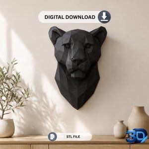 Peut inclure: Une sculpture murale en forme de tête de panthère noire au design géométrique low-poly. La structure présente des facettes angulaires nettes formant les traits du félin. Une étiquette blanche indique DIGITAL DOWNLOAD et une autre STL FILE.