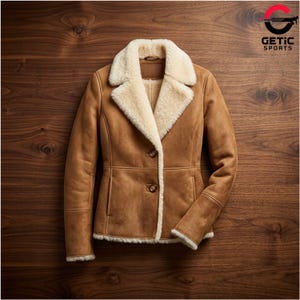 May include: A brown suede jacket with a cream-colored shearling lining and collar. The jacket has a classic design with two buttons and a tailored fit. The cuffs and hem are also trimmed with shearling.