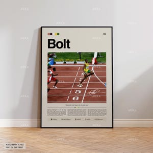 Può includere: Un poster incorniciato con il nome "Bolt" a grandi lettere, raffigurante una scena di atletica leggera. L'immagine mostra un corridore in uniforme giallo e verde su una pista rossa. Il poster include testo e una firma.