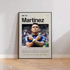 Puede incluir: Un póster enmarcado con el nombre "Martinez" en negro en la parte superior. Debajo, una foto de un jugador de fútbol con una camiseta azul y negra, con los brazos cruzados. El póster incluye texto y una firma. El póster está en una pared.