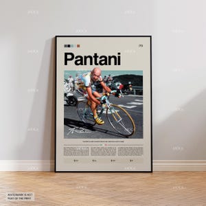 Może przedstawiać: Oprawiony plakat z napisem "Pantani" dużymi czarnymi literami, przedstawiający kolarza w akcji. Obraz zawiera tekst na dole i paletę kolorów na górze. Kolarz ma na sobie kolorową koszulkę i jedzie na rowerze.