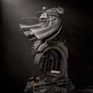 May include: A detailed statue of a figure in a long coat and hat, standing atop a crumbling structure with a vintage typewriter. The statue is dark gray, with a dramatic pose, set against a rainy backdrop. The overall theme is mysterious and gothic.
