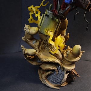 May include: A detailed figurine featuring a stylized, weathered base with a textured, tree-like appearance. The figurine has a green and yellow container, with yellow lightning bolt accents. The figure is set against a dark background.