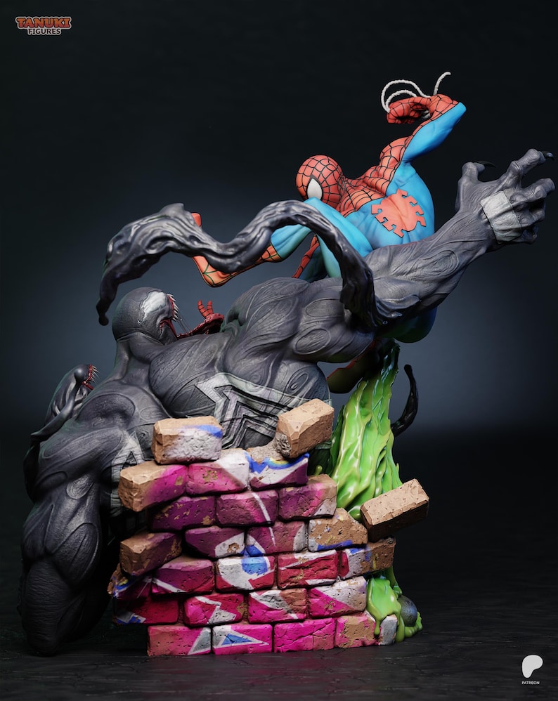 May include: A detailed figurine depicting Spider-Man battling Venom. Spider-Man is in a dynamic pose, clad in his classic red and blue suit. Venom is a large, dark figure with a menacing expression. The base features a brick wall with graffiti.