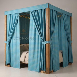 Puede incluir: Una cama con dosel con estructura de madera y cortinas de cuadros azul claro. Las cortinas están atadas a los postes de madera. El marco de la cama tiene esquinas metálicas decorativas. El texto "LOOMOIRE" es visible en la parte posterior de la cama.