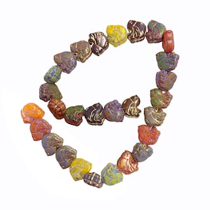May include: A strand of bird-shaped beads in a variety of colors including yellow, purple, green, orange, and brown. Each bead features a molded bird silhouette with metallic gold-toned detailing along the wings and body, arranged in a loose curve.