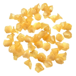 May include: A collection of translucent, light orange-yellow flower-shaped beads. Each bead has a petal design and a small hole for stringing. The beads are scattered against a white background, ideal for jewelry making or craft projects.