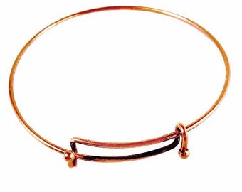 May include: A copper-colored adjustable bangle bracelet. The bracelet features a circular design with an adjustable mechanism. The adjustable section is a rectangular shape with a small ball on each end. The bracelet is designed to be worn on the wrist.