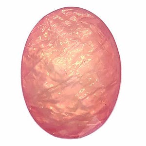 May include: Oval-shaped, polished gemstone in a soft pink hue. The surface has a textured appearance with subtle variations in color, creating a shimmering effect. The gemstone is set against a plain white background.