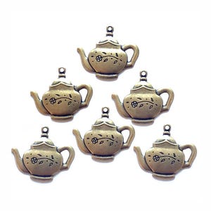 May include: Six bronze-colored teapot charms with floral and leaf details. Each charm has a loop at the top for attaching to jewelry or other crafts. The teapots have a vintage, antique appearance.