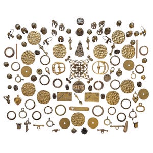 May include: A collection of antique brass-toned metal jewelry findings including hammered circular discs, jump rings, ornate filigree connectors, small keys, buckles, and rectangular charms with the text "Post Card" and "I love you".