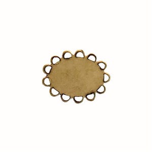 May include: A small, oval-shaped brass jewelry finding with a scalloped edge. The center is a flat, unadorned surface. The finding is set against a plain white background, highlighting its shape and color.