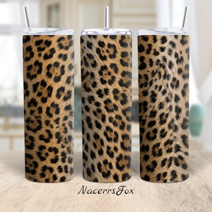 May include: Three cylindrical tumblers featuring a brown, tan, and black leopard print pattern. Each tumbler has a clear lid and a silver metal straw inserted through the top. The text NacerrsFox is printed in black at the bottom center.