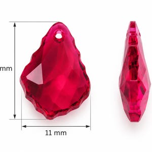 Può includere: Un ciondolo in cristallo sfaccettato color rosa intenso con una forma organica irregolare e un piccolo foro nella parte superiore per l'aggancio. Il ciondolo misura 16 mm in altezza e 11 mm in larghezza, mostrato di fronte e di profilo.