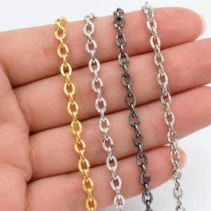 Könnte beinhalten: Vier Metallketten in verschiedenen Ausführungen sind nebeneinander dargestellt. Die Ketten bestehen aus ovalen Gliedern und sind in Gold, hellem Silber, dunklem Gunmetal-Grau und einem helleren Silberton erhältlich, alle mit einheitlichem Design.